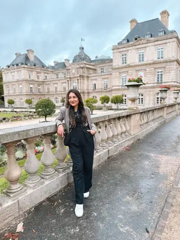 Camila num terraço do Jardim de Luxemburgo, com o palácio ao fundo