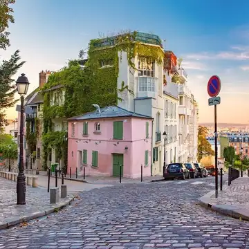 Rua colorida de Montmartre, com uma casa rosa coberta de hera